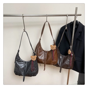 Vue détaillée des sacs hobo en noir, caramel et café avec des pendentifs oursons