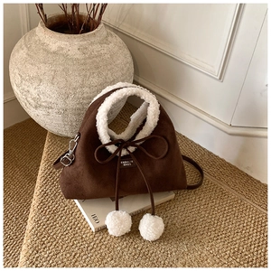 Détail du sac à bandoulière en daim avec bordure en polaire et nœuds à cordon de serrage