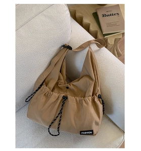 Close-up of khaki nylon drawstring tote with Fashion label and adjustable cord detail
