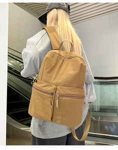 Detailed view of the khaki lightweight nylon backpack featuring waterproof fabric and zipper pockets