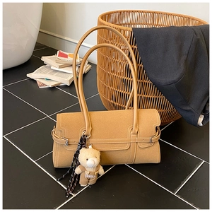 Détail du sac Boston camel avec charm ours et foulard géométrique sur la bandoulière
