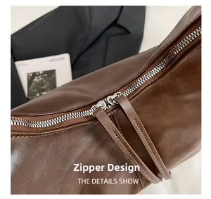 Détail de la double fermeture éclair avec tirettes en cuir sur sac cabas marron