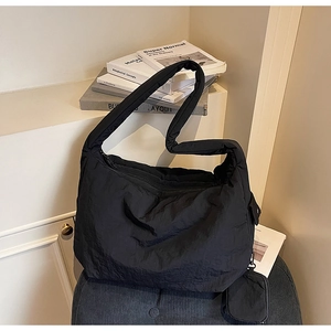 Detailansicht der schwarzen gesteppten Hobo-Bag aus Nylon mit Mini-Beutel und Reißverschluss