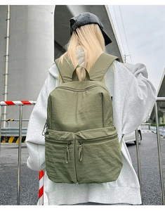 Outdoor street view of the army green nylon backpack with large main compartment