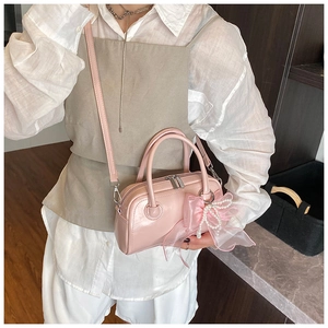 Sac à main Boston rose avec nœud en perles et bandoulière réglable sur modèle