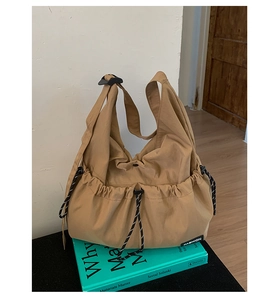 Detailed view of khaki nylon crossbody bag with drawstring pockets and fashion label