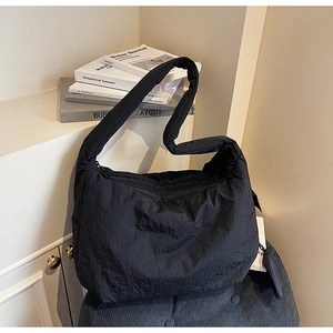 Detailansicht der schwarzen Nylon-Tasche mit Faltenstruktur und gepolstertem Schultergurt
