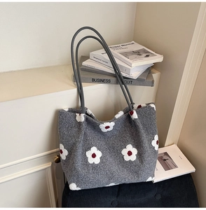 Detail of grey plush tote bag with white floral pattern and slim leather straps