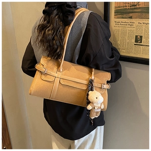Détail du sac Boston en daim kaki avec boucle vintage et pendentif ours de mode