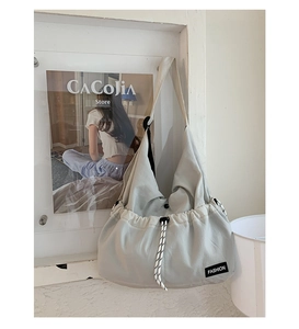 Detailed view of lightweight nylon crossbody bag with woven drawstring and fashion label