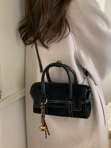Black suede crossbody bag with contrast white stitching and round dual handles