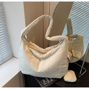 Detail einer großen gesteppten Schultertasche in Creme mit passender Mini-Tasche