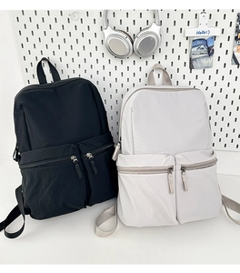 Close-up of minimalist nylon backpack dual front zipper pockets and waterproof texture