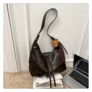 Détail du sac hobo café noir avec breloque ours en peluche et décor d'ordinateur