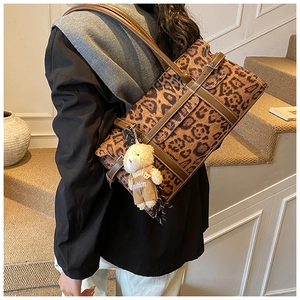 Détail du sac Boston léopard avec lanières en cuir marron et pendentif ours mignon