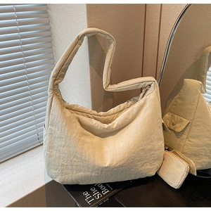 Detailansicht der beigen gesteppten Hobo-Tasche mit passender kleiner Geldbörse und weichem Stoff