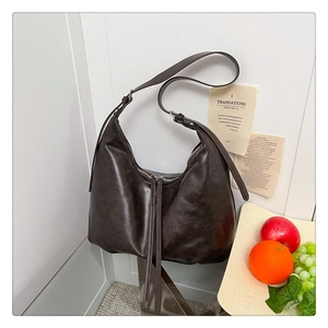 Détail du sac hobo en cuir café avec double fermeture éclair et longues tirettes