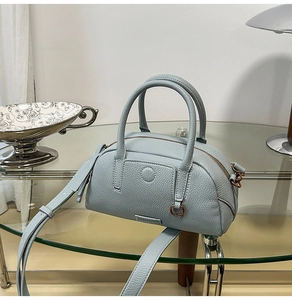 Close-up of light blue lychee pattern leather Boston bag with vintage metal hardware