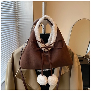 Détails du sac en daim marron avec garniture en polaire blanche et nœuds à pompons