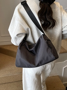 Minimalist white checkered crossbody pillow bag with adjustable black strap and metal zipper