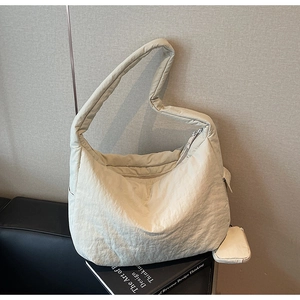Detail einer cremeweißen großen Tasche mit Textur und abnehmbarem Münzfach am Gurt