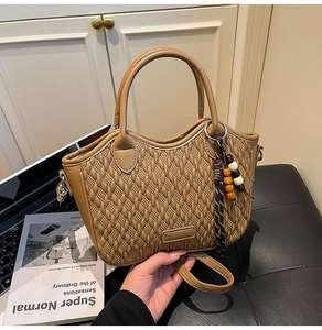 Detailed texture of brown woven bucket bag with beaded tassel and detachable strap