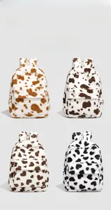 Detail of four fuzzy plush backpacks showing cow print textures in various animal colorways