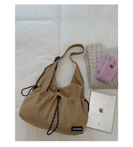 Detail of drawstring khaki nylon crossbody bag with side knots and fashion tag