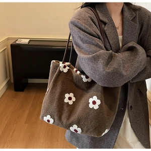 Detail of dark brown suede tote bag with 3D daisy flower embroidery and slim shoulder strap