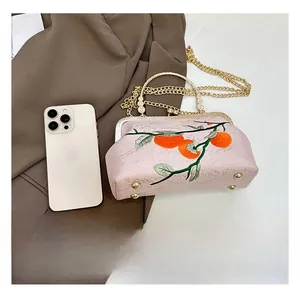 Détail du sac à main rose brodé avec motif kaki et fermoir rétro en métal de luxe
