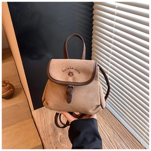 Detail of camel suede bucket backpack with floral embroidery and brown leather trim