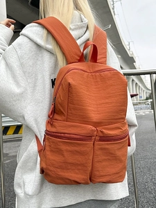 Lightweight bright orange wrinkled nylon backpack with dual front pockets for students