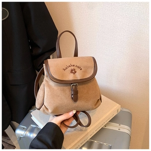 Detail of vintage suede bucket backpack with flower embroidery and brown leather trim