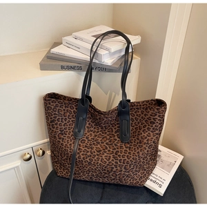 Détail macro du grand sac cabas imprimé léopard avec des poignées en cuir noir élégant