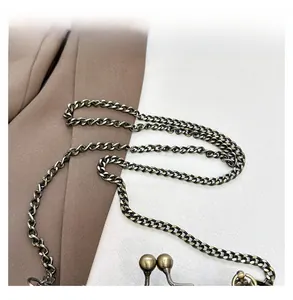 Detailed macro view of vintage bronze chain and spherical clasp on a handbag