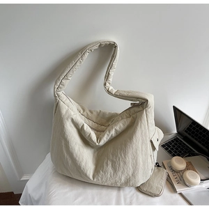 Detaillierte Makroaufnahme einer cremefarbenen Nylon-Hobo-Tasche mit passender Geldbörse