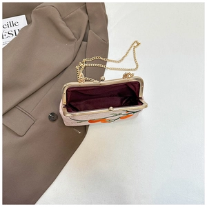 Détail du sac brodé vintage avec fermoir doré kiss-lock et doublure intérieure bordeaux