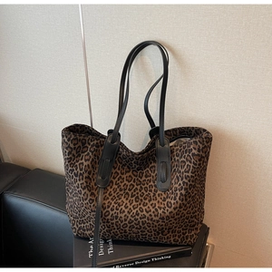Détail du sac cabas en daim imprimé léopard avec de fines anses noires pour femmes