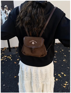 Rear view of model wearing brown frosted bucket backpack with cute floral embroidery