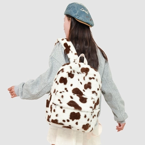 Macro detail of the plush cow print fabric and front zipper pocket on the backpack