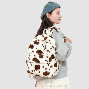 Detail of plush faux fur backpack with cow print pattern on a fashion model