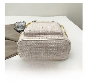 Dettaglio del fondo resistente di questo zaino in tweed con borchie dorate