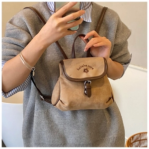 Detail of vintage matte bucket backpack with floral embroidery and brown leather strap