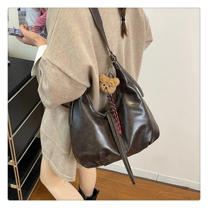 Sac hobo en cuir marron avec charme d'ours, vue latérale arrière sur un mannequin