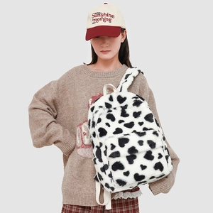 Detail of plush backpack with white faux fur and black heart patterns for winter