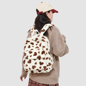 Detail of plush milk-white backpack with coffee heart patterns and fuzzy straps