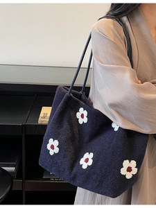 Navy blue plush tote bag with flower embroidery shown as stylish shoulder carry