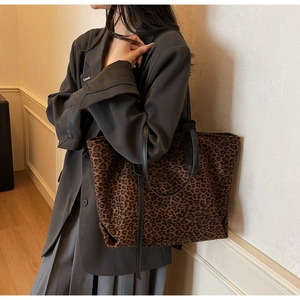 Détail du sac cabas en suédine à imprimé léopard avec anses noires en cuir souple