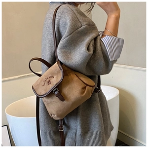Detail showing brown canvas and leather trim of the vintage bucket backpack with embroidery