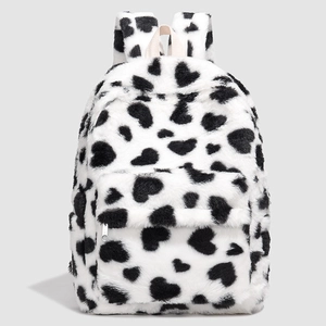 Close-up of fuzzy heart-pattern plush backpack with metal zipper and soft cow print texture